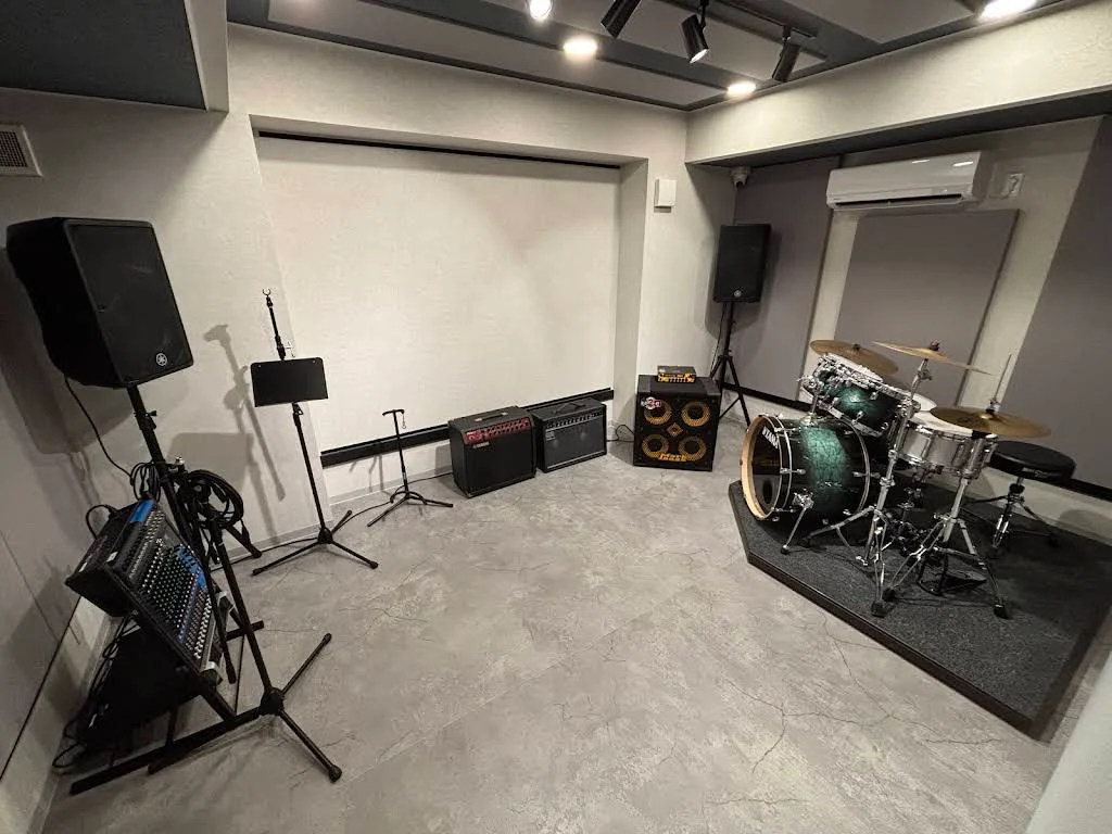 STUDIO PORTのスタジオ全景。マイク、アンプ、ドラムセットを備えた明るい室内
